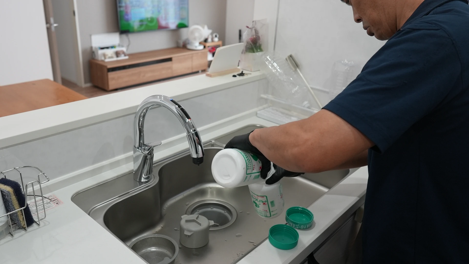 台所の排水口まわりを確認する作業風景